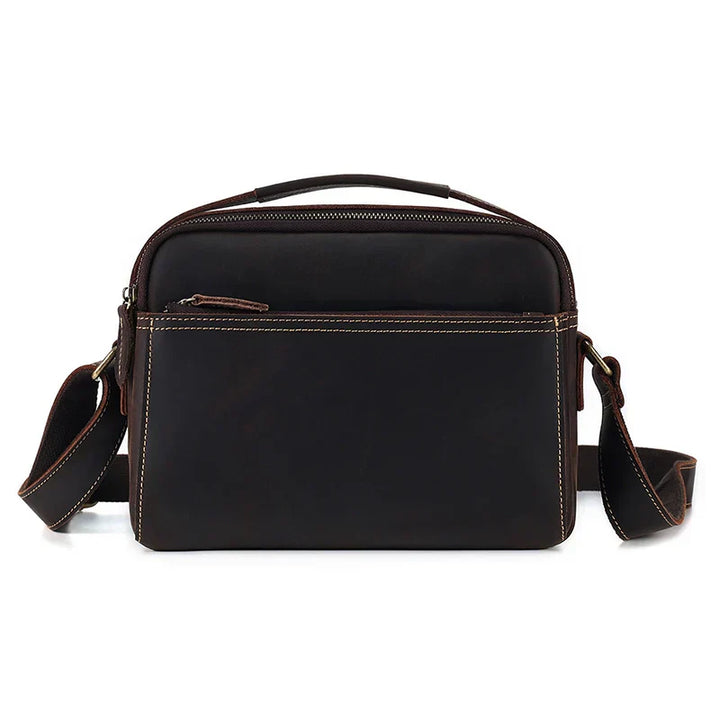 Borsa a tracolla in pelle marrone scuro, design elegante e compatto, con cerniera frontale e tracolla regolabile. Accessorio moda uomo/donna.