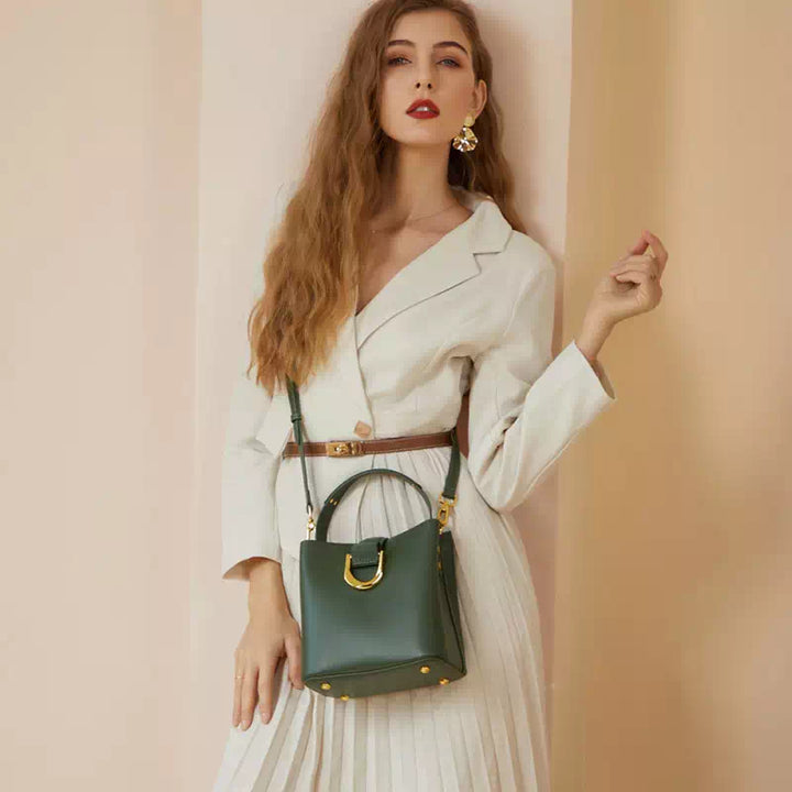 Donna con abito bianco elegante e borsa verde in pelle, posa sofisticata. Moda femminile, accessori di lusso, stile chic.