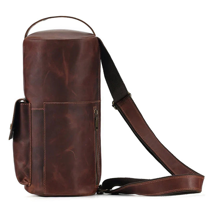 Zaino monospalla in pelle marrone, design elegante e compatto, con tasche multiple e tracolla regolabile. Ideale per viaggi e uso quotidiano.