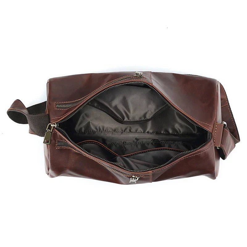 Borsone da viaggio in pelle marrone con cerniera aperta, tasche interne, tracolla regolabile. Elegante e spazioso, ideale per viaggi e weekend.