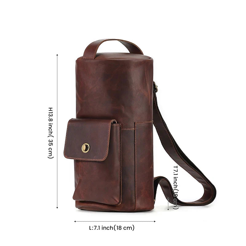Borsa a tracolla in pelle marrone, design cilindrico, con tasca frontale e chiusura a bottone, dimensioni 18x35 cm, ideale per uomo e donna.