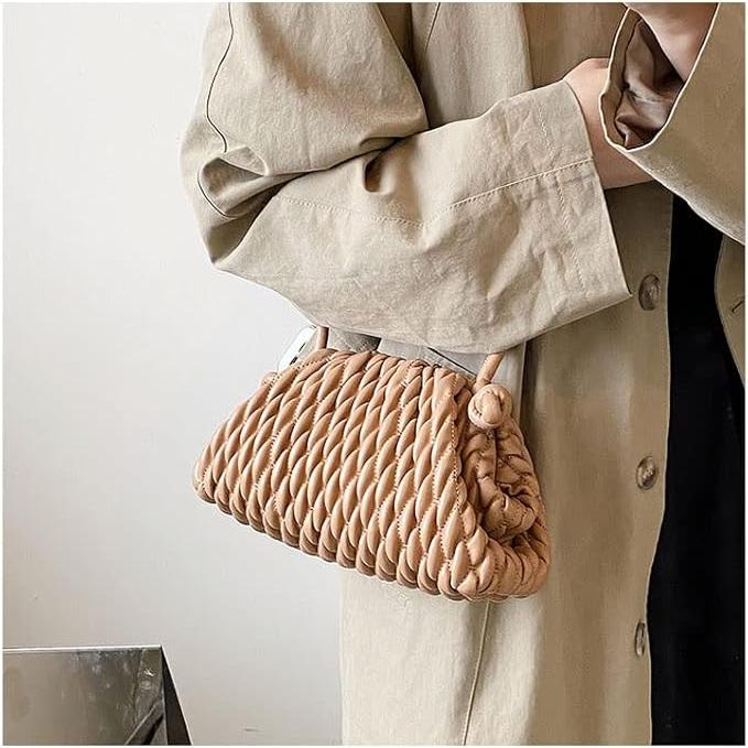 Borsa a mano intrecciata beige, design elegante, indossata con cappotto beige. Accessorio moda donna, stile casual chic.