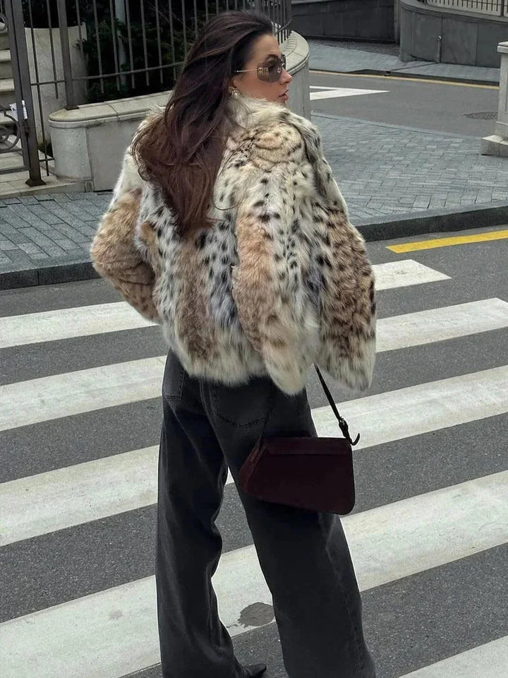 Manteau ample femme en fausse fourrure blanche avec motif animal, adapté pour les journées fraîches.