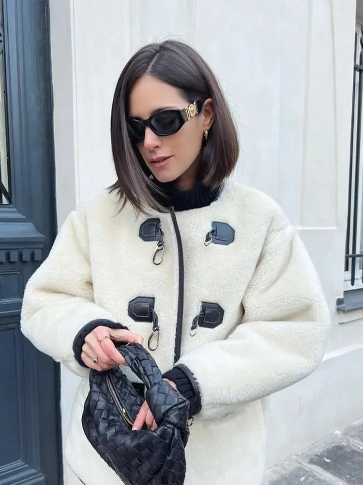 Manteau chaud femme en matériau doux, avec fermeture décorative et coupe élégante, idéal pour les jours frais.