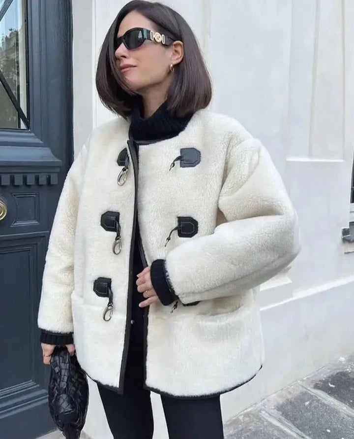 Manteau chaud femme beige avec fermeture décorative et silhouette élégante.