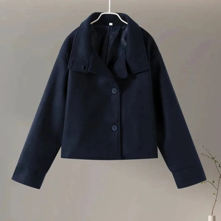 Manteau court femme gris avec boutons et col montant, design moderne et élégant.