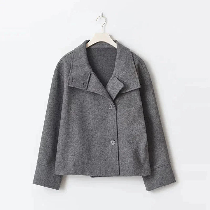 Manteau court femme bleu foncé avec boutons et col montant, conçu pour les journées fraîches.