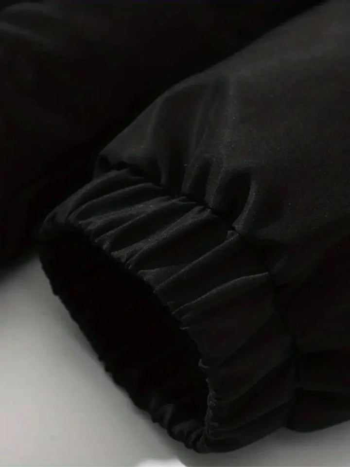 Doudoune noire pour femme avec capuche, doublure douce et poches pratiques, adaptée aux journées froides.