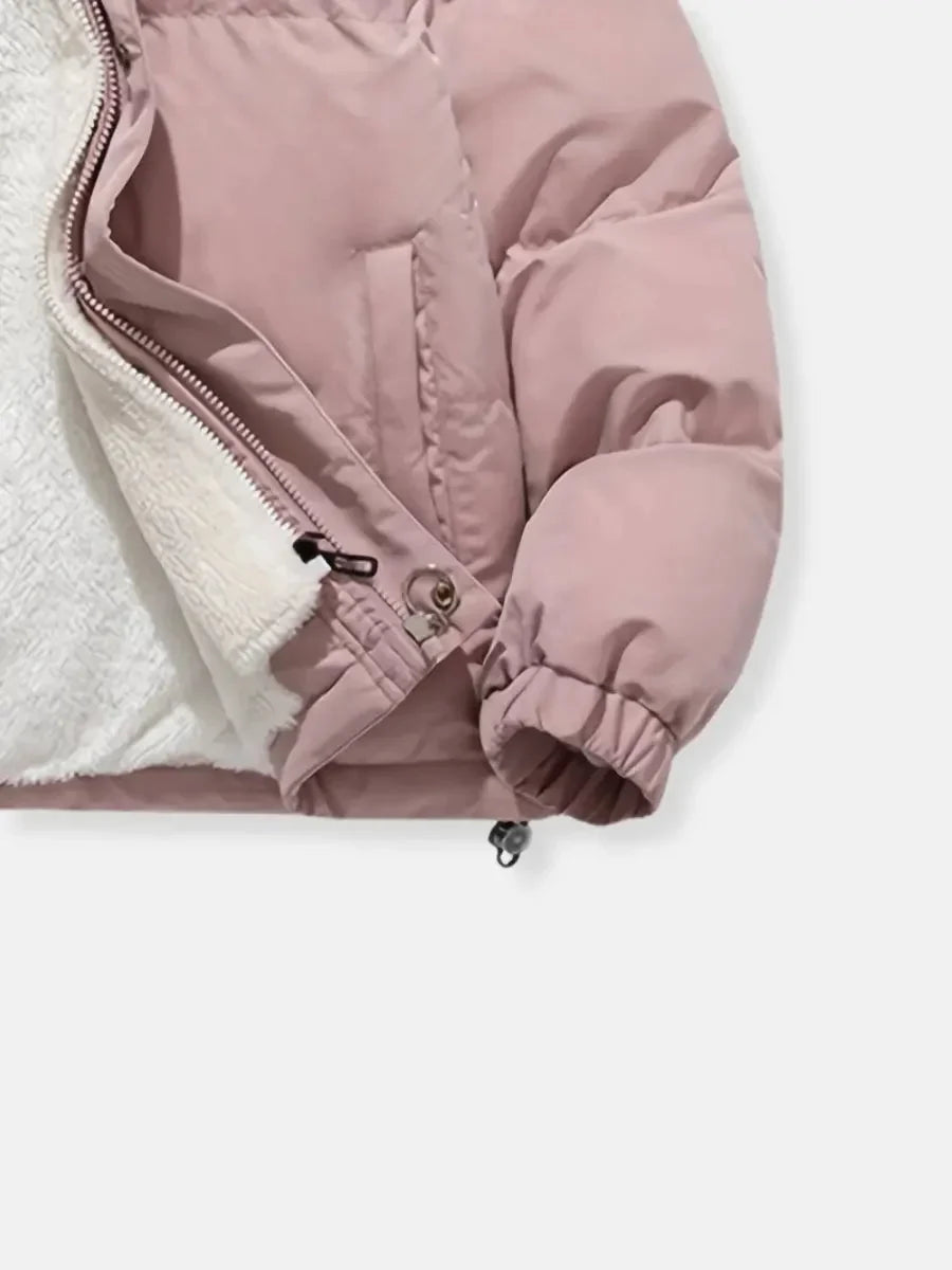 Doudoune d'hiver rose pour femme, avec capuche et doublure douce pour un confort accru.