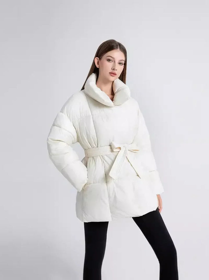 Manteau d'hiver femme noir avec ceinture, col élégant et tissu chaud pour les journées fraîches.