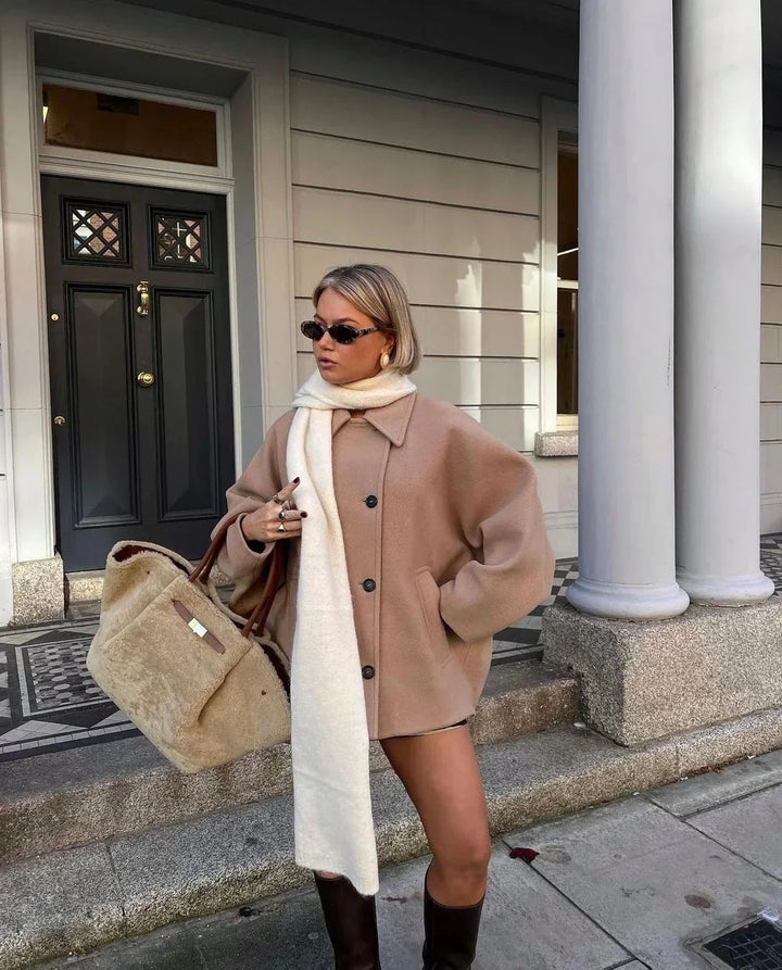 Manteau femme ample en tissu doux, avec grands revers et boutons décoratifs pour un style classique.