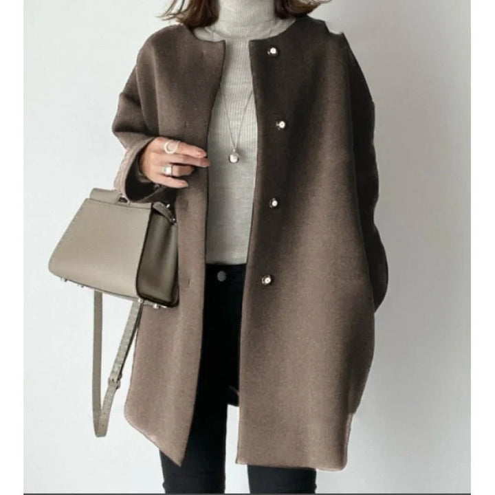 Manteau noir pour femme avec boutons, coupe moderne adaptée à diverses occasions.