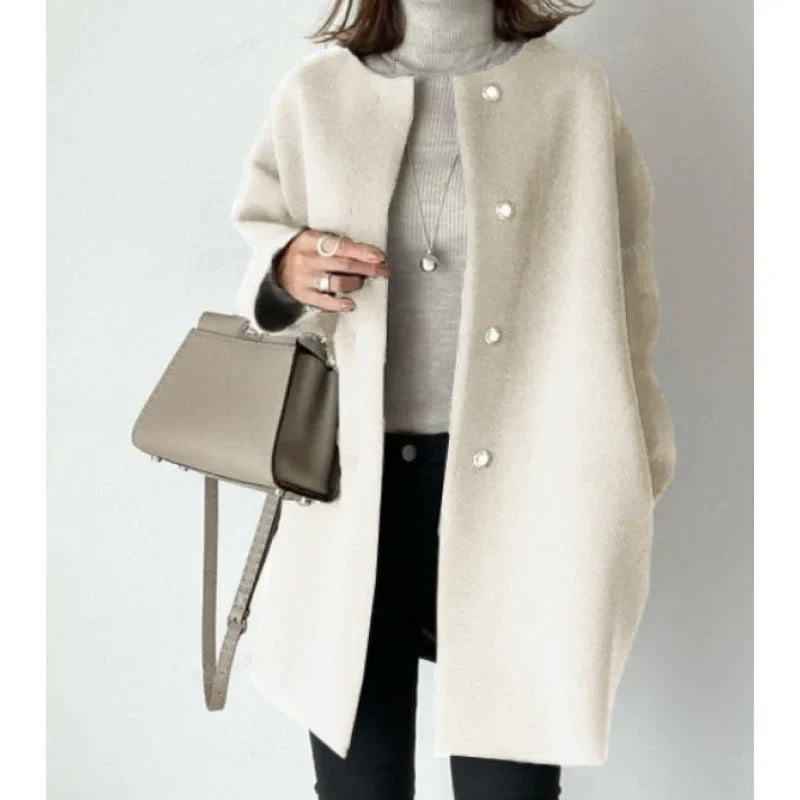 Manteau femme noir avec boutons modernes, en tissu doux, adapté pour l'automne.