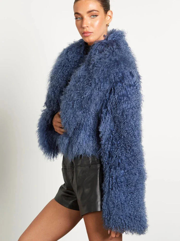 Manteau femme bleu en tissu doux, manches longues, silhouette simple et élégante, adapté pour les jours frais.