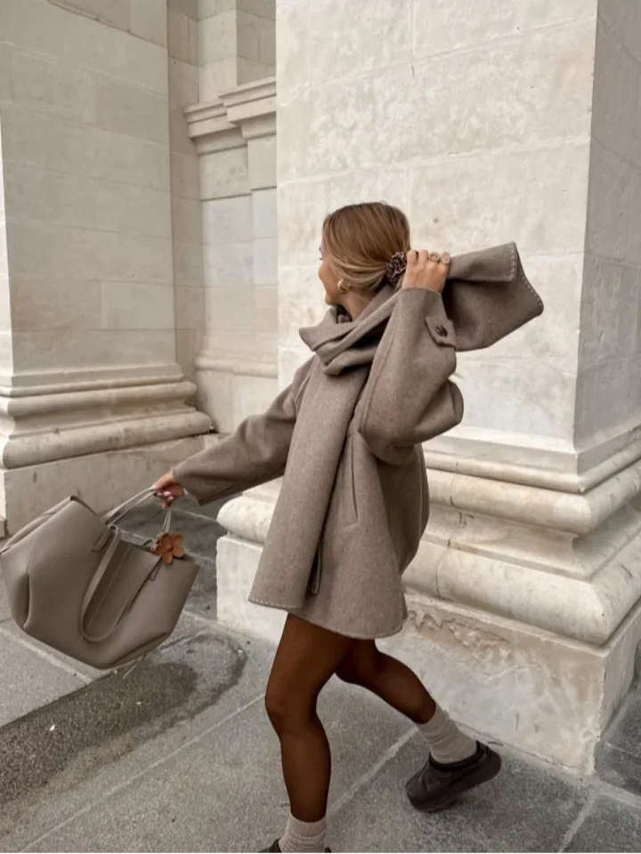 Manteau femme taupe en tissu doux, avec écharpe intégrée et boutons, adapté pour les journées froides.