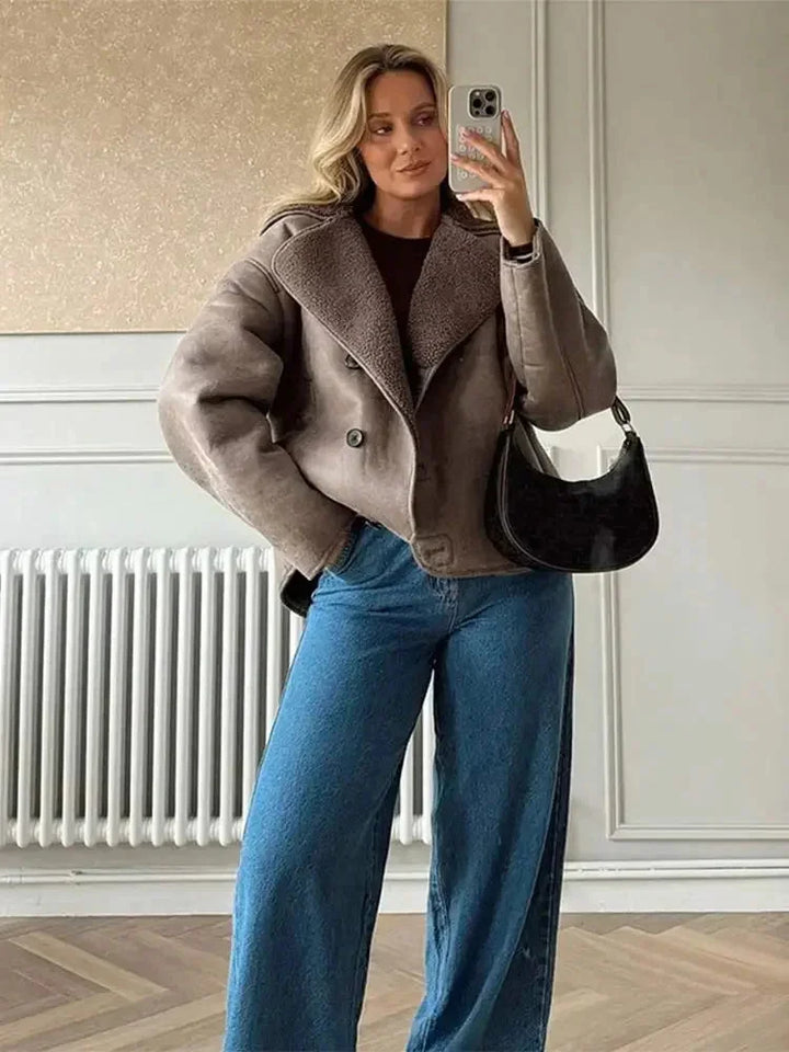 Manteau femme taupe avec col teddy, boutons et tissu doux pour les journées fraîches.