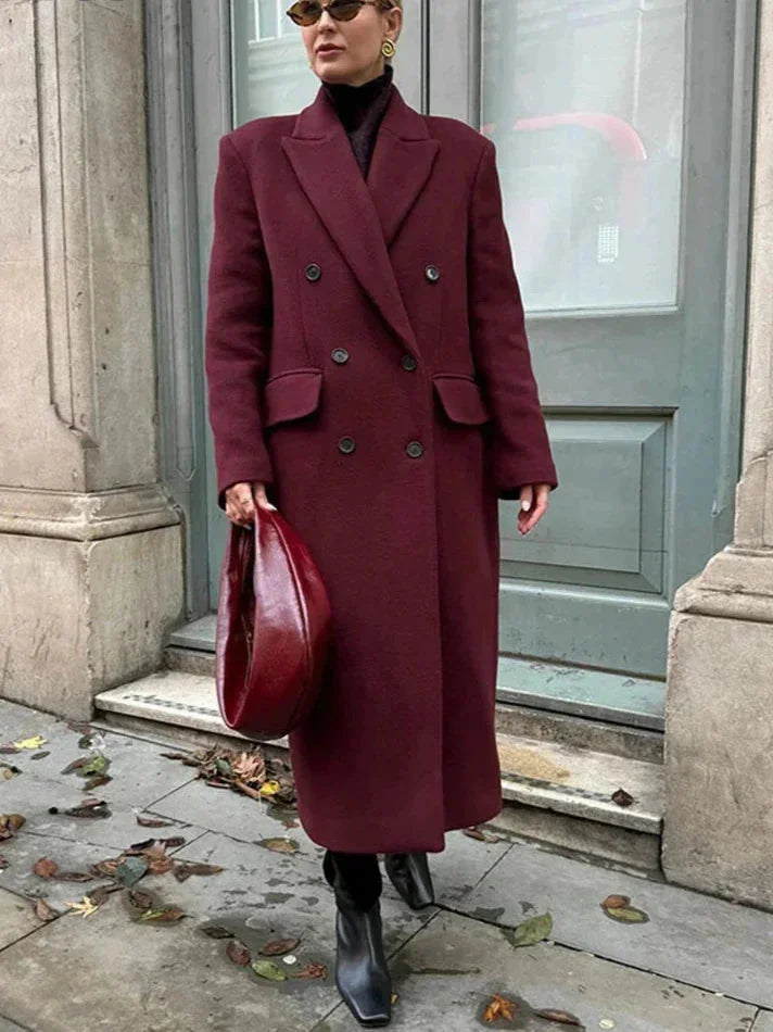 Manteau long bordeaux pour femme, double boutonnage, col à revers, coupe élégante en tissu doux.
