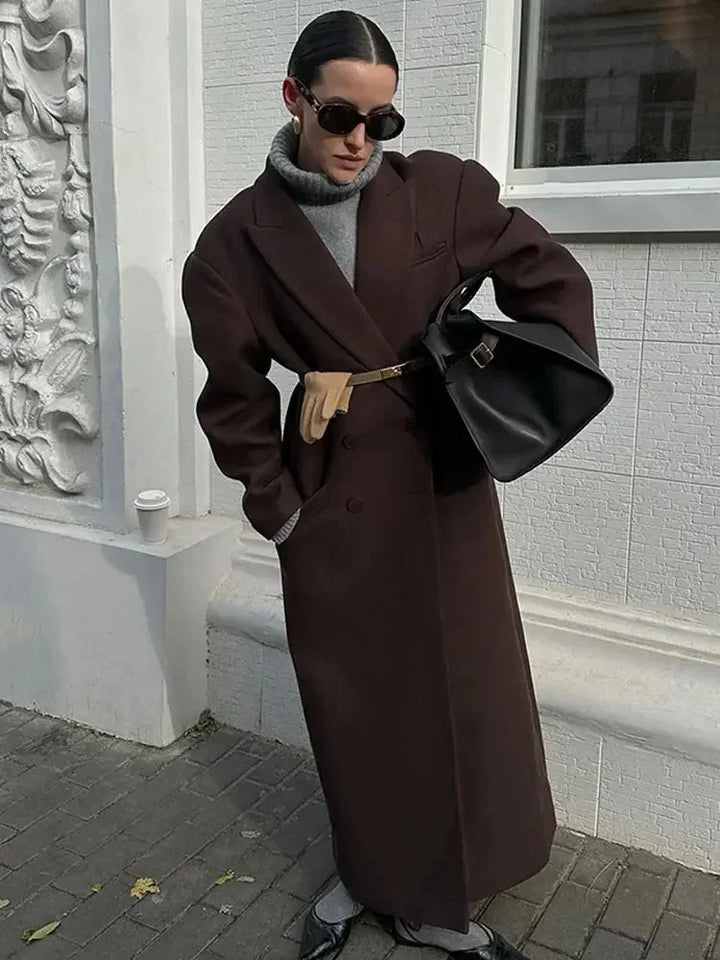 Manteau long marron pour femme, manches volumineuses, coupe ajustée, idéal pour des occasions élégantes.