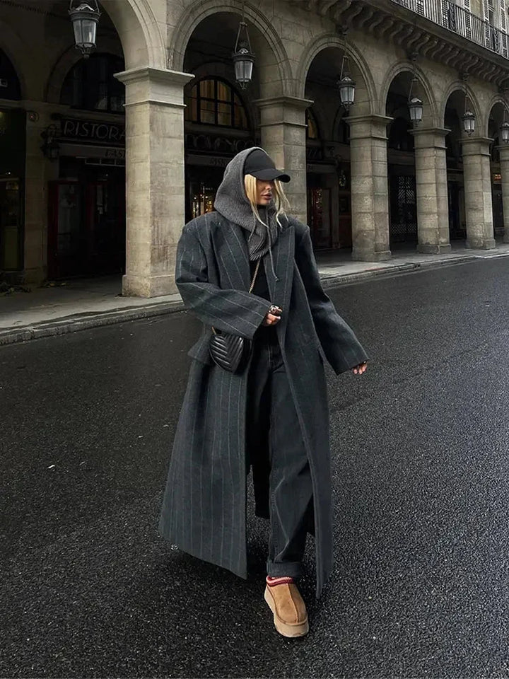 Manteau long femme gris foncé à rayures, en tissu doux, avec poches pratiques et coupe moderne.
