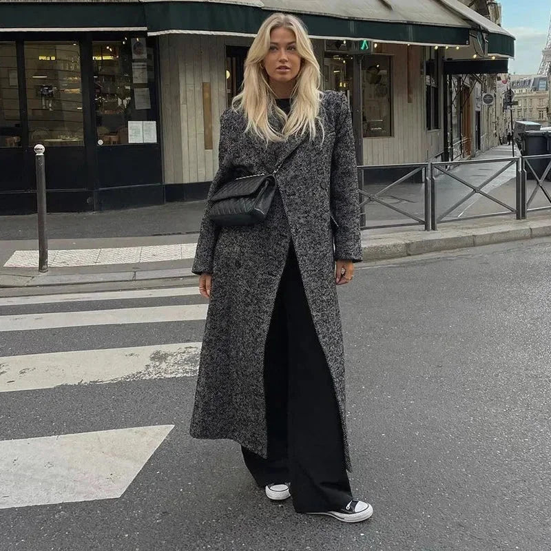 Manteau long gris femme à manches longues, en tissu doux, avec un design moderne et un bouton de fermeture.