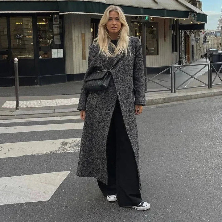 Manteau long gris femme à manches longues, en tissu doux, avec un design moderne et un bouton de fermeture.