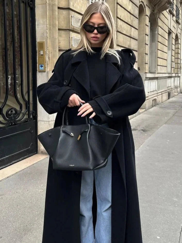 Manteau long noir femme avec ceinture, larges revers et tissu doux pour un confort optimal.