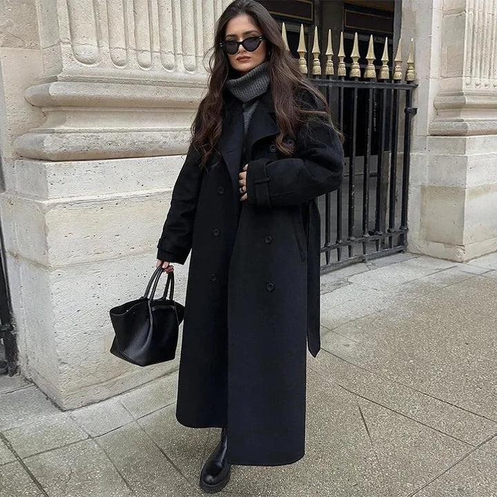 Manteau mi-long femme en tissu doux, avec ceinture à la taille et boutons décoratifs.