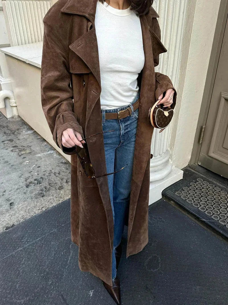 Manteau trench femme marron avec ceinture, col à revers et poches latérales en matériau léger et résistant aux intempéries.