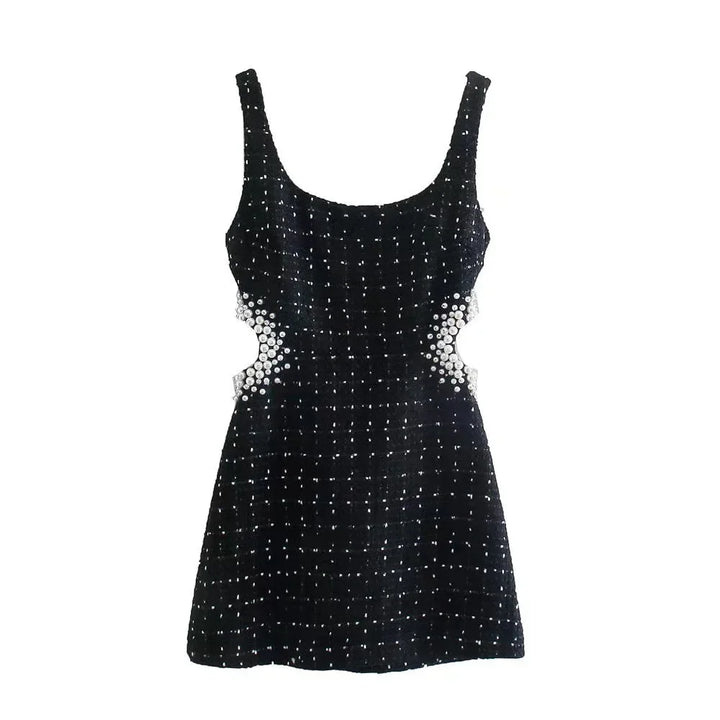 Mini robe noire en tissu léger, ornée de perles, avec découpes élégantes et manches épaules nues pour un look sophistiqué.