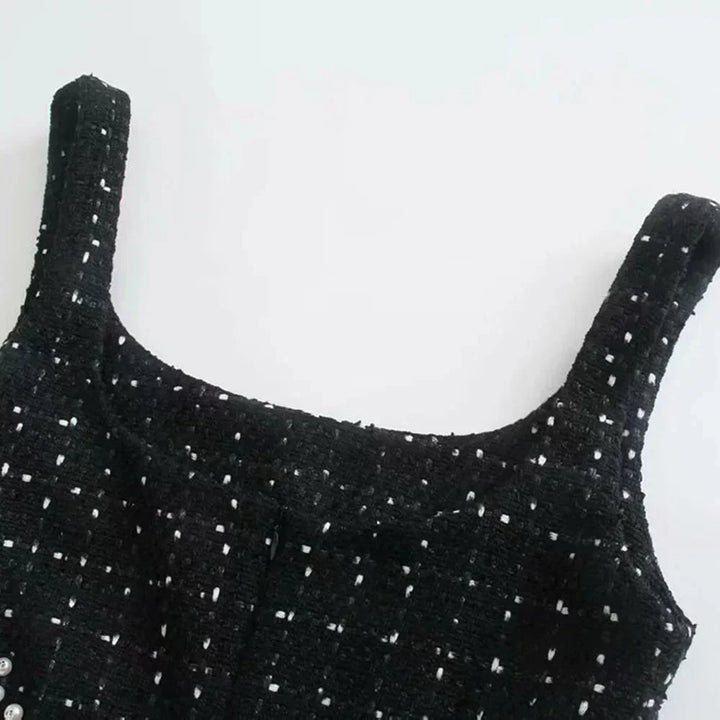 Mini robe noire perlée avec découpes, manches épaules nues, en tissu fluide et élégant, idéale pour soirées et événements.