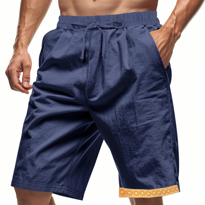 Shorts sportivi blu da uomo con tasche laterali e bordo decorativo arancione. Ideali per allenamento, palestra, tempo libero. Tessuto leggero e traspirante.