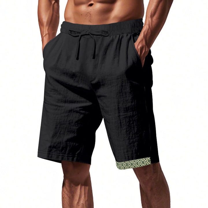 Pantaloncini uomo neri con elastico in vita e tasche, dettagli geometrici verdi sull&