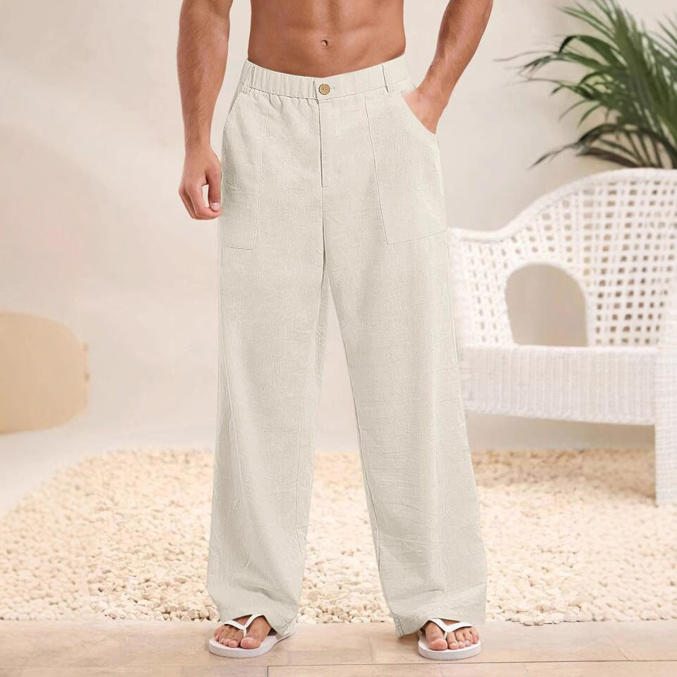 Pantaloni larghi da uomo in lino bianco, stile casual estivo, con tasche laterali. Indossati con sandali, ambientazione interna moderna.