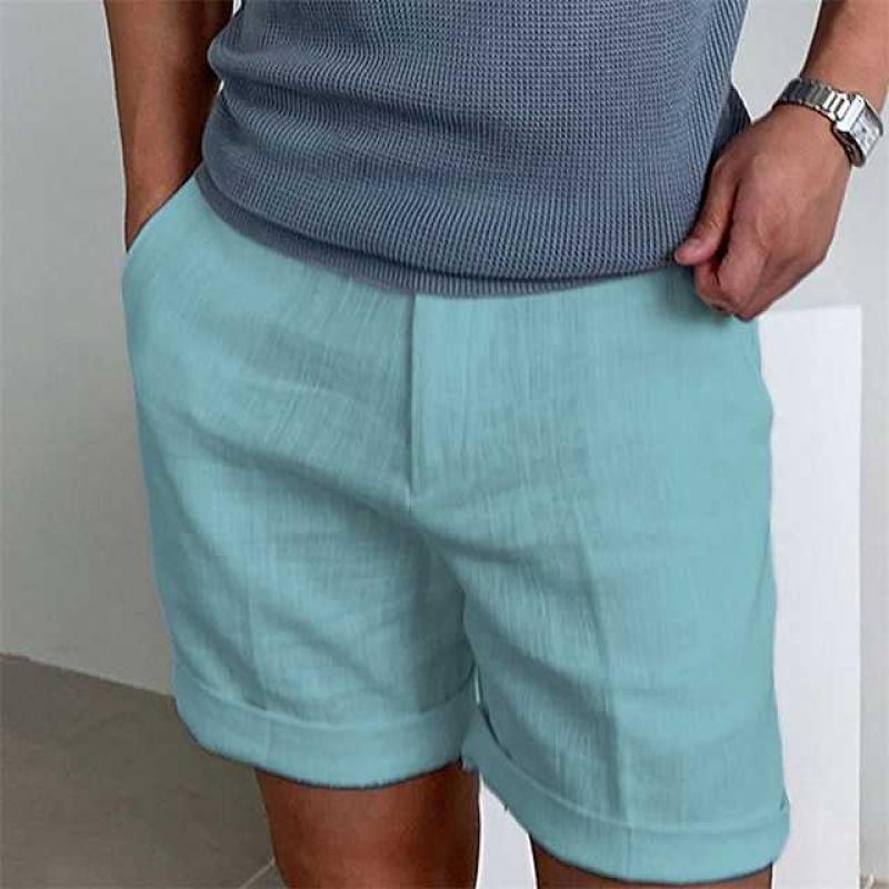 Uomo con pantaloncini azzurri in lino, maglietta grigia, orologio al polso. Moda estiva casual, abbigliamento maschile elegante e confortevole.