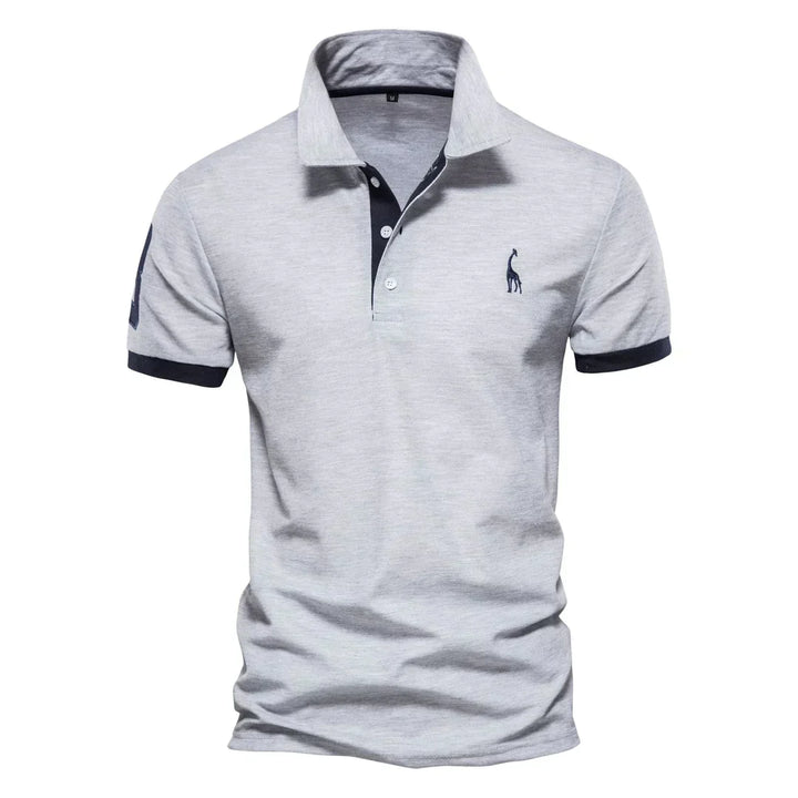 Polo uomo grigia, maniche corte, colletto classico, logo ricamato, dettagli blu scuro. Elegante e casual, ideale per moda maschile estiva.
