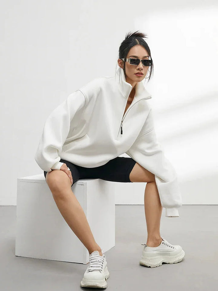 Pull à capuche femme oversize blanc en coton, avec demi-zip et coupe décontractée.