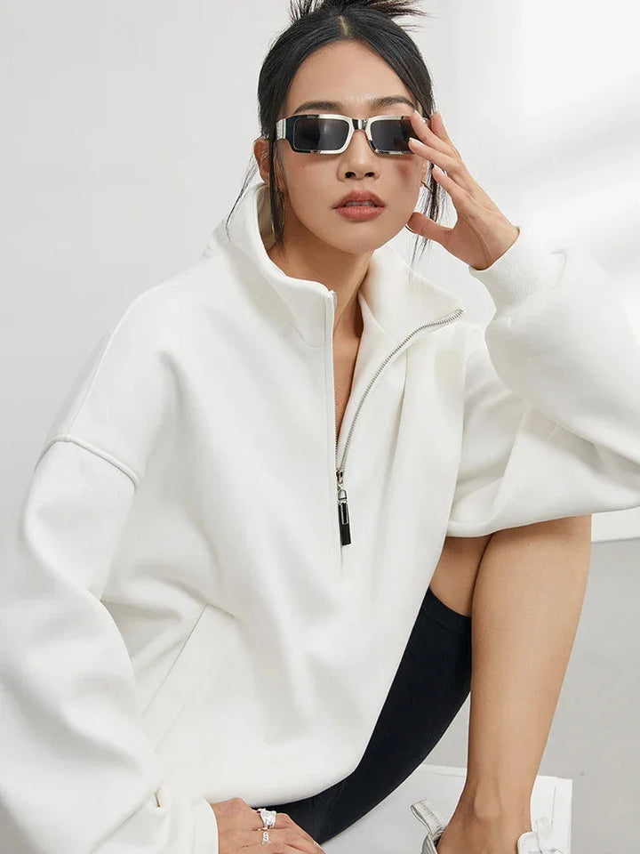 Pull à capuche femme oversize blanc en coton, avec demi-zip et coupe décontractée.