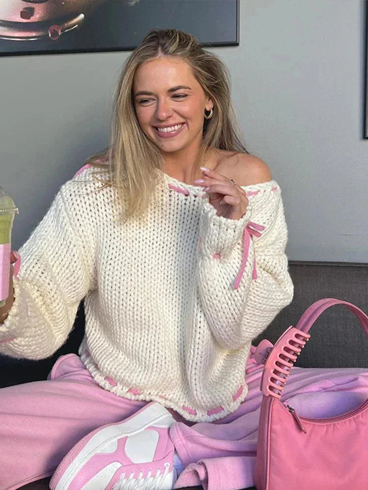 Pull femme asymétrique rose avec attaches, en matière douce et respirante pour un style décontracté.