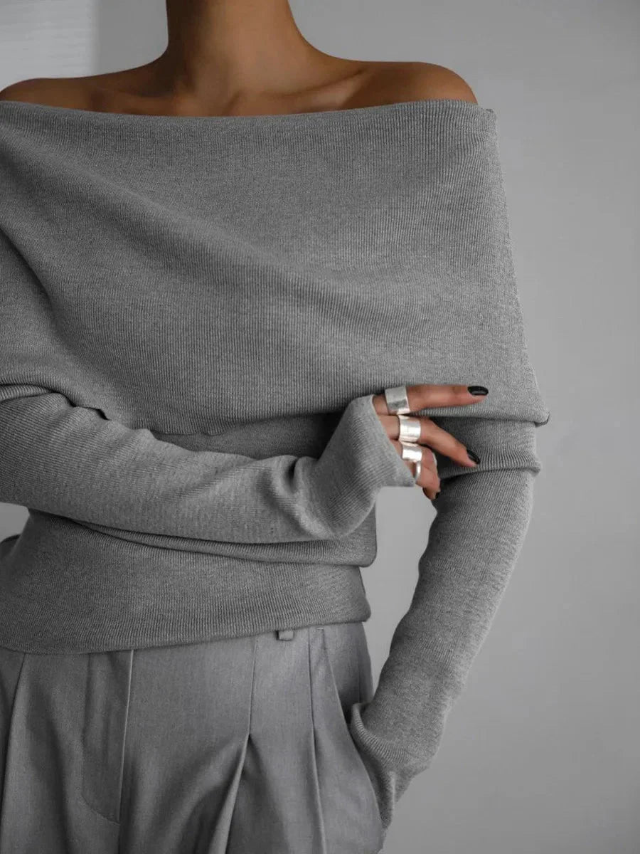 Pull femme gris à col bateau, manches longues, en matière douce.