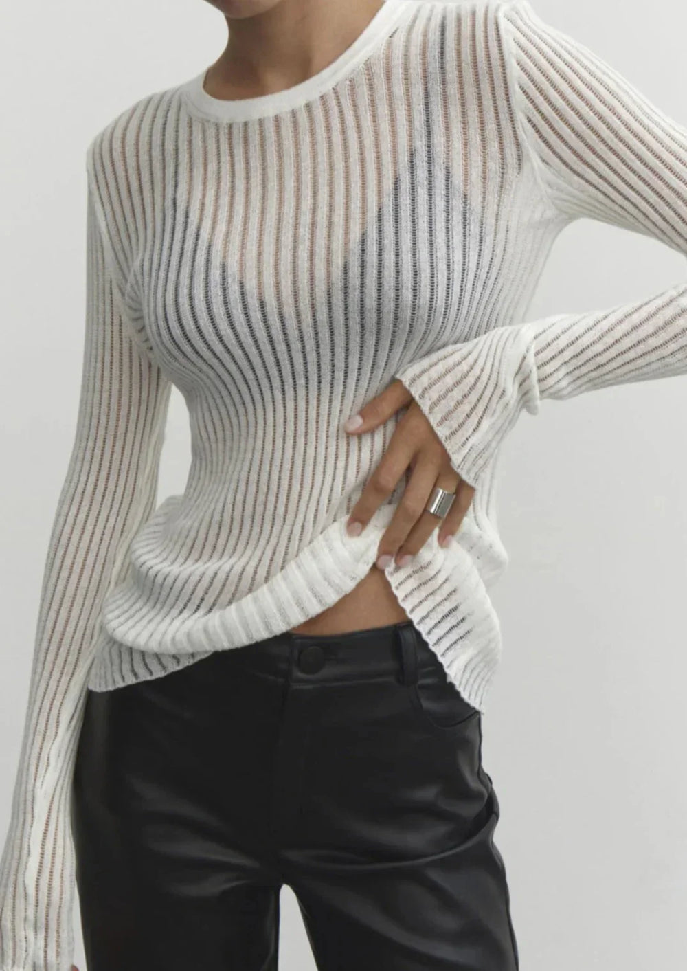 Pull femme noir en maille côtelée, transparent, au design décontracté et à la coupe moderne.