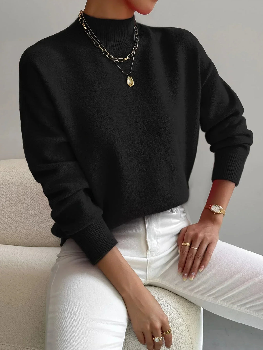 Pull féminin blanc à col montant, en tissu extensible, à manches longues, adapté pour les journées fraîches.