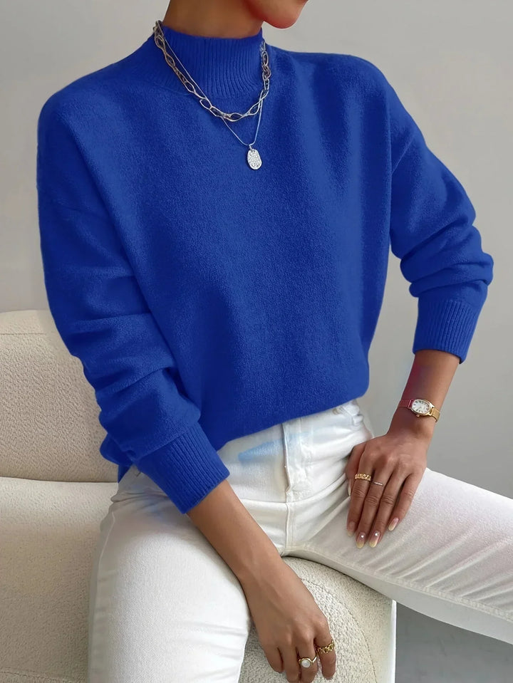 Pull féminin rose clair, col montant, en tissu extensible, manches longues, coupe moderne et épurée.