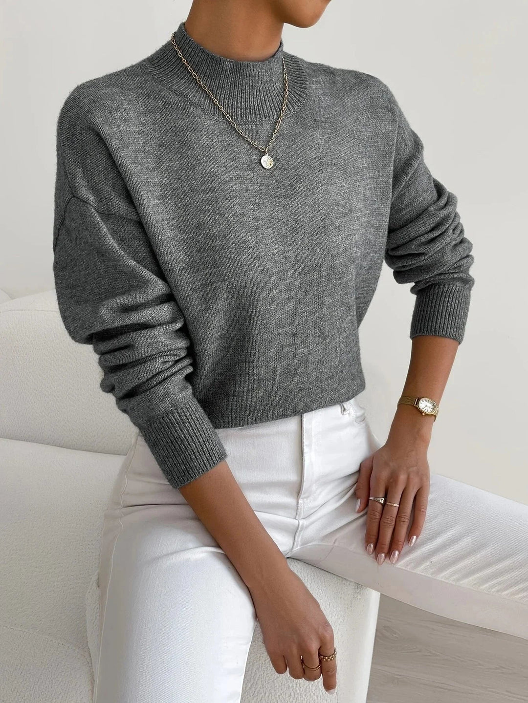 Pull féminin rose clair, col montant, tissu extensible, manches longues.