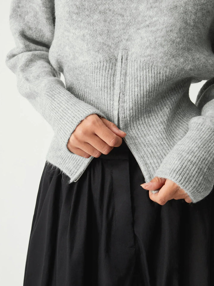 Pull gris femme avec demi-zip, manches longues et tissu doux.
