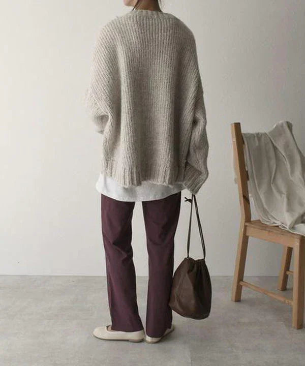 Pull oversize gris femme en matière douce, avec poche et coupe décontractée pour un usage quotidien.