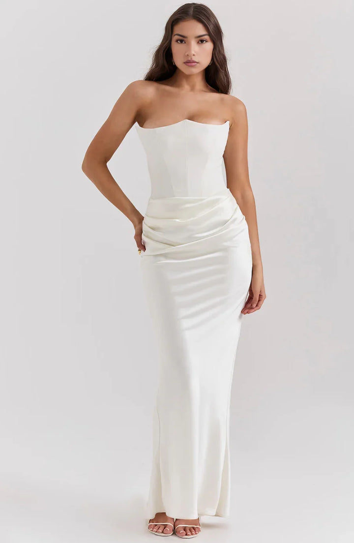 Robe bustier maxi blanche en tissu drapé, avec une coupe élégante et fluide, idéale pour les occasions estivales.