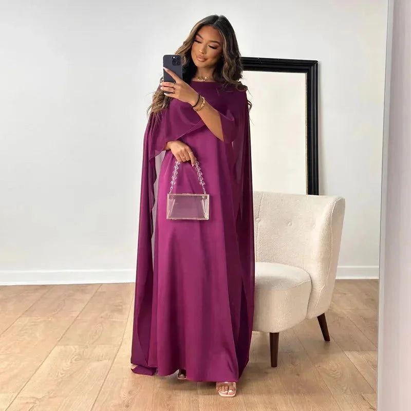 Robe maxi beige pour femme, coupe fluide avec cape, silhouette élégante et féminine.