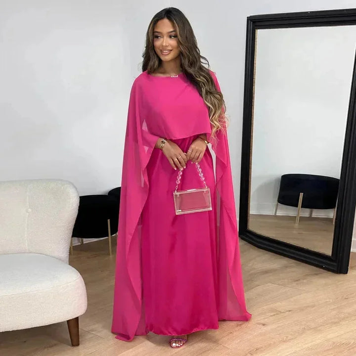 Robe maxi beige femme avec cape, coupe fluide en tissu léger, adaptée pour diverses occasions.