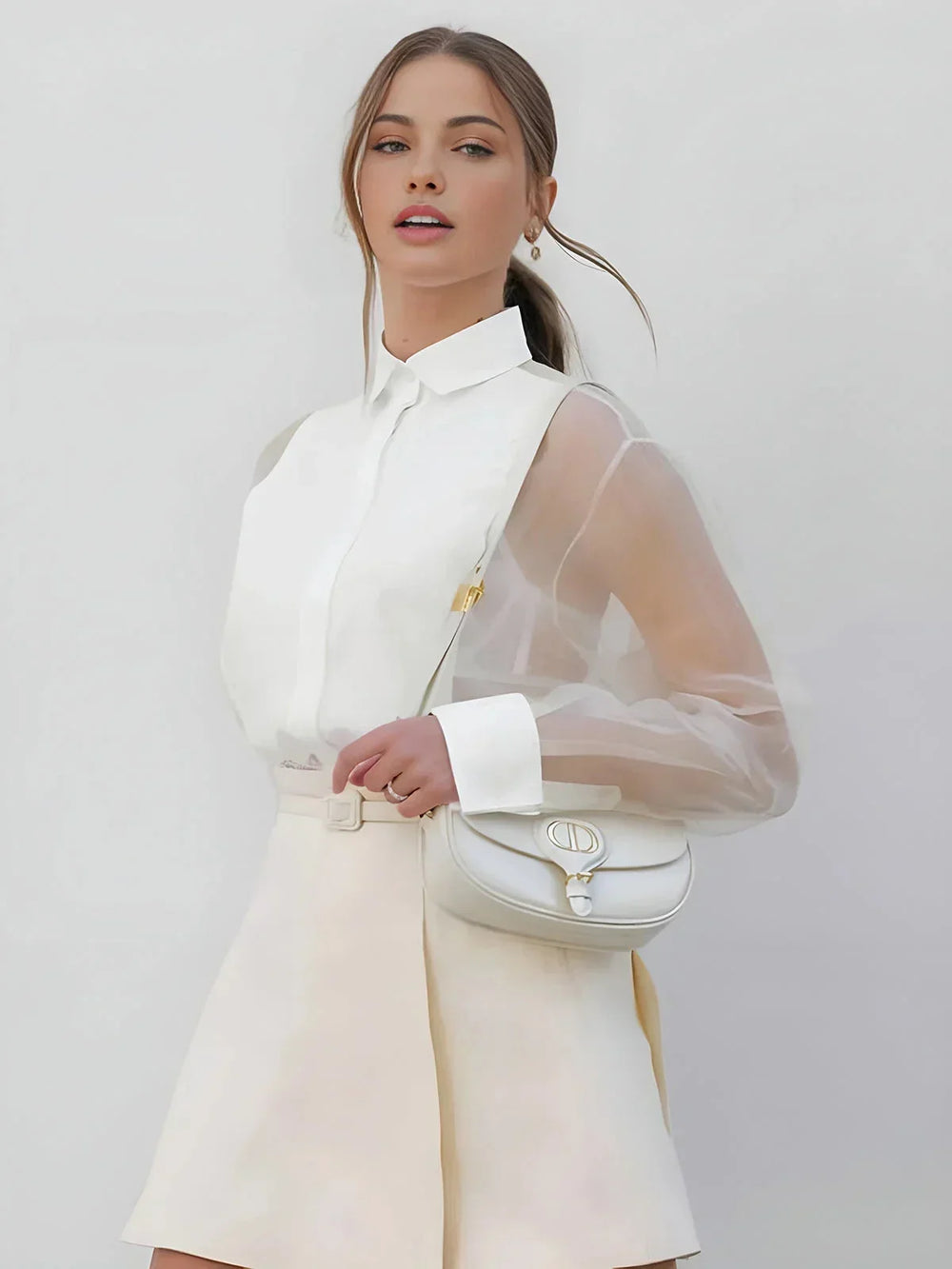 Robe courte blanche avec col chemise, manches transparentes en tissu léger, parfaite pour un look professionnel élégant.