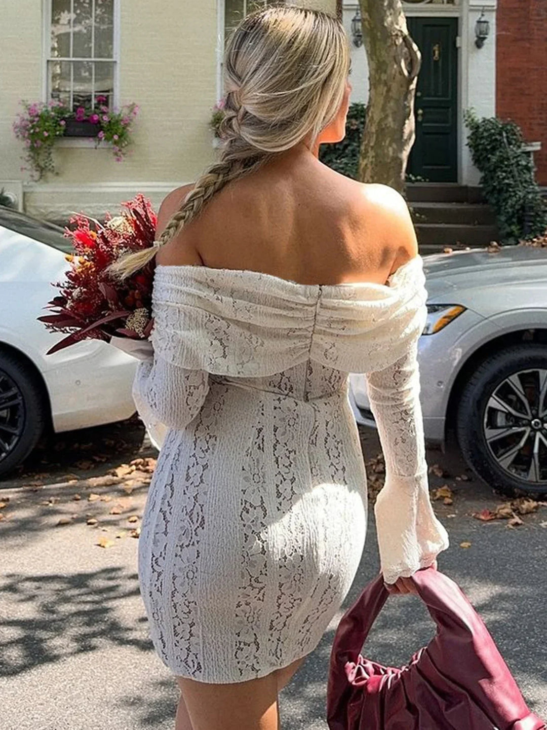 Robe courte en dentelle blanche, à épaules dénudées, avec un design floral et une finition délicate.